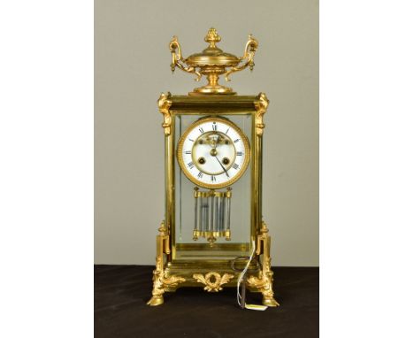 A LATE 19TH CENTURY BRASS AND GILT METAL MANTEL CLOCK, with twin handled urn finial above a case with four glass panels, whit