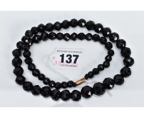 A FACETED JET BEAD NECKLACE, of a graduated faceted bead design, the beads measuring between 7.8-15.0mm, strung on a black co
