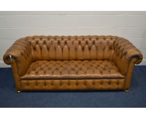 A TAN LEATHER BUTTONED CHESTERFIELD SOFA, along with later cushions, width 205cm