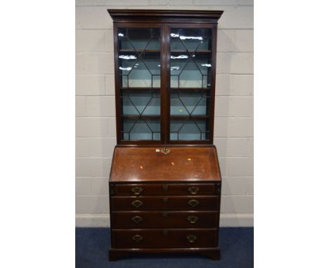 A GEORGE III MAHOGANY AND WALNUT CROSSBANDED BUREAU BOOKCASE, the top with an overhanging cornice, double astragal glazed doo