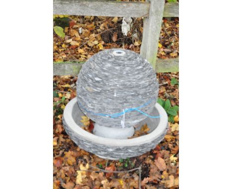 A WOODLODGE LAGOON WATER FEATURE constructed from slate shards around a composite structure with water pump and transformer, 