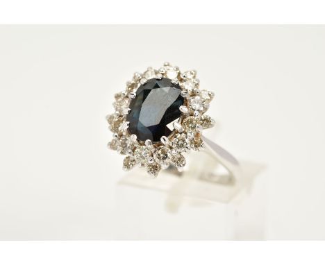 A MODERN SAPPHIRE AND DIAMOND OVAL CLUSTER RING, sapphire measuring approximately 10.2mm x 7.8mm, surrounded by a double halo