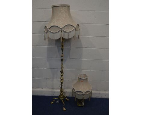 A MID TO LATE 20TH CENTURY BRASS STANDARD LAMP on tripod legs, with a fabric shade, together with a gilt resin figural table 