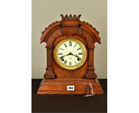 A LATE 19TH CENTURY ANSONIA WALNUT CASED MANTEL CLOCK, the arched case with carved detail, enamel dial with Roman numerals, e