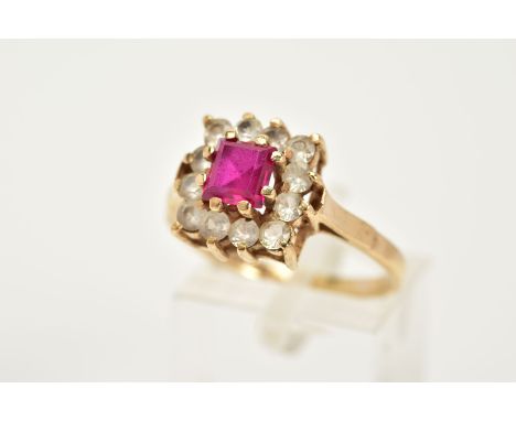 A 9CT GOLD CLUSTER RING, designed as a square cluster, set with a ventral square cut ruby, within a circular cut colourless s