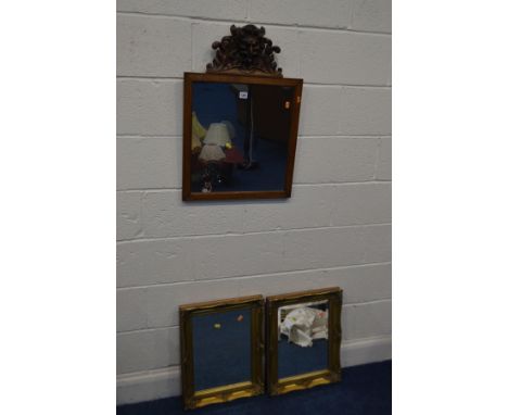 AN OAK WALL MIRROR with a carved mythical creature to the finial, 51cm x 73cm, together with a pair of gilt wood framed wall 