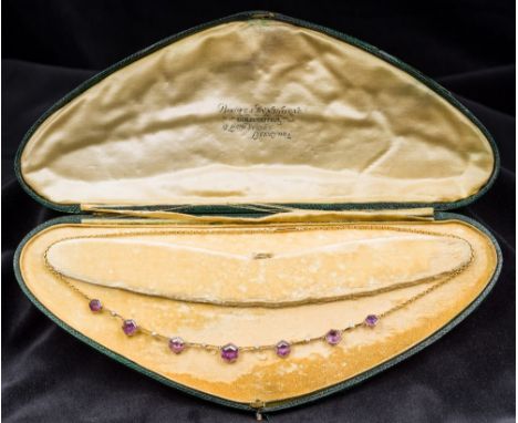 A late Victorian/Edwardian unmarked gold amethyst and seed pearl necklaceSet with seven graduated facet cut hexagonal amethys