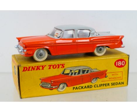 Dinky Toys - A boxed Dinky Toys #180 Packard Clipper Sedan. The model with orange lower body, light grey upper body, grey rai