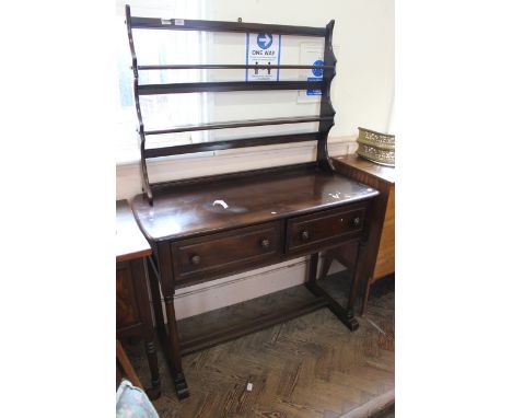 An Ercol style stained elm small cottage dresser with rack and standing on four turned legs with stretcher