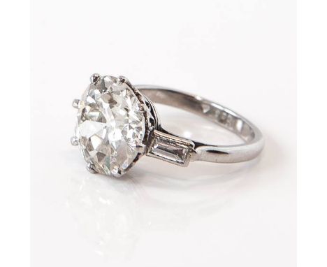 A platinum 6.74ct old cut solitaire diamond ring, with two baguette cut diamonds to each shoulder, 0.50ct, assessed colour K,