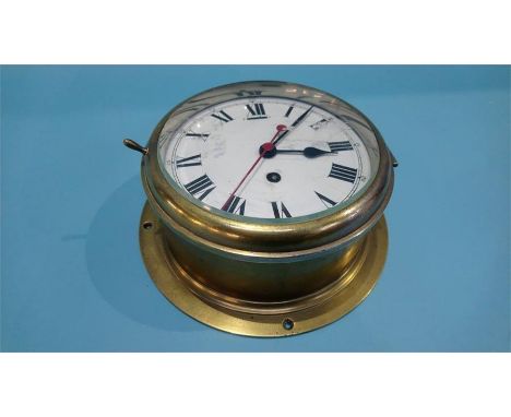 A brass ships clock with enamelled dial