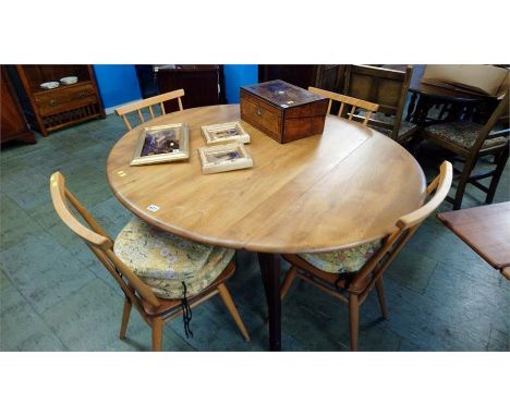 A set of four Ercol spindle back chairs with solid seats and a Golden Dawn drop leaf table