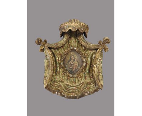 A Spanish painted gilt wood wall plaque, 18th/19th century centred by an oval oil portrait of the Madonna and Child, each fig