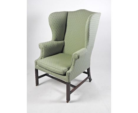 A George III style mahogany framed wing back armchair, 19th century, upholstered in green covers and raised on square legs jo