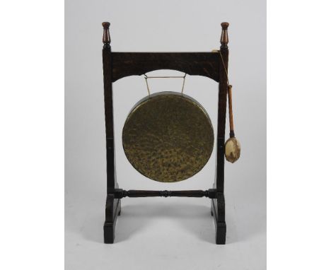 A Victorian Gothic oak dinner gong, third quarter 19th century with turned finials, the brass gong above a turned stretcher b