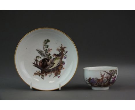 A Meissen porcelain teacup and saucer, 18th century, painted in polychrome with decoration of figures hunting a stag and houn
