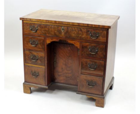 A mahogany and walnut veneered knee-hole dressing table of George III design, the rectangular top above a frieze drawer and r