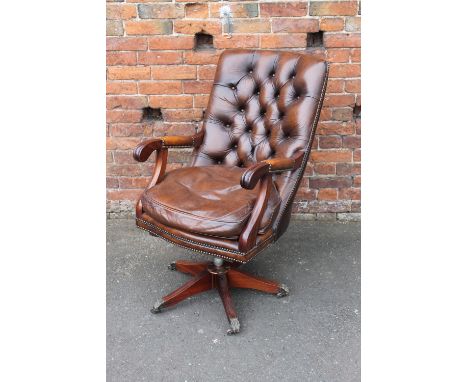 A 20TH CENTURY MAHOGANY LEATHER SWIVEL ARMCHAIR, having shaped button back, loose seat cushion, raised on a five leg base, br