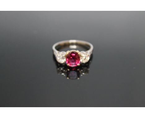 A WHITE GOLD RUBY AND DIAMOND RING, with yellow gold setting for the ruby which is approx 1.47 carats, with three small diamo