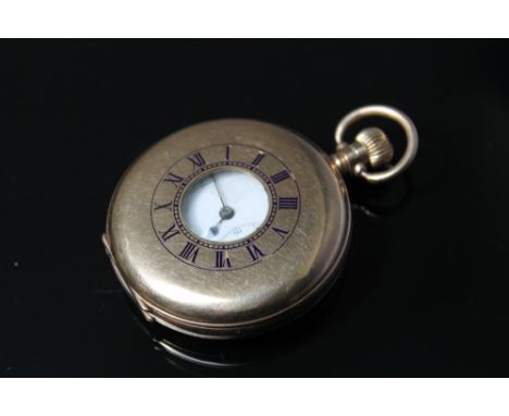 A HALLMARKED 9 CARAT GOLD MANUAL WIND HALF HUNTER POCKET WATCH, having black Roman numeral outer dial, white enamel dial, Rom