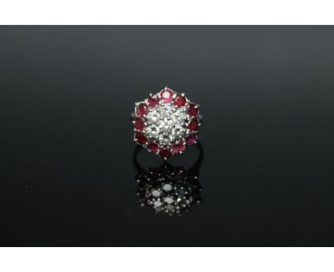 A 18 CARAT WHITE GOLD RUBY AND DIAMOND RING, set with seven brilliant cut diamonds to the centre totalling approx 0.70 carat,