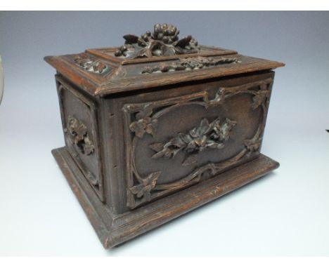 A CARVED DECORATIVE OAK TEA CADDY, the hinged lid opening to reveal two lidded canisters, paper label inside lid 'WIRTH BROTH