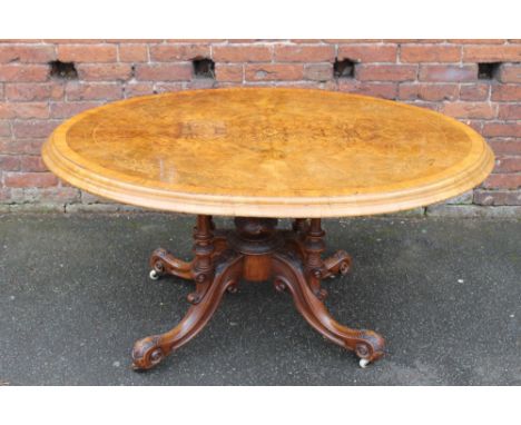 A VICTORIAN WALNUT INLAID OVAL LOO TABLE, the top with original snap lock mechanism, raised on a four carved column support a