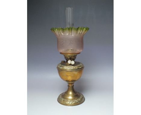 A BRASS BODIED OIL LAMP WITH ETCHED GLASS SHADE, the brass oil lamp with embossed decoration, Duplex burner, and glass funnel
