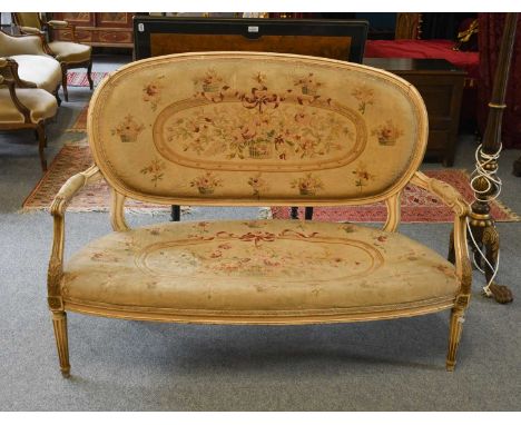 An early 20th-century French style painted and parcel-gilt hardwood parlour settee with original needlepoint upholstery and r