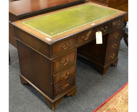 A mid 20th century mahogany kneehole desk, tooled leather top , bracket feet  