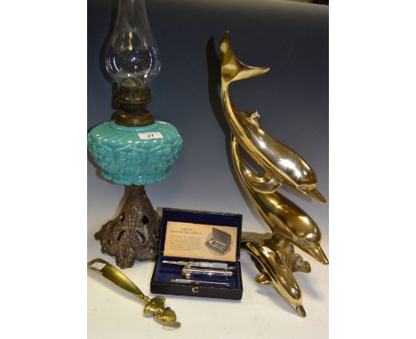 A Victorian cast iron and blue opaque glass oil lamp;  a brass dolphin group;  another, smaller;  a Agla Micrometer syringe; 