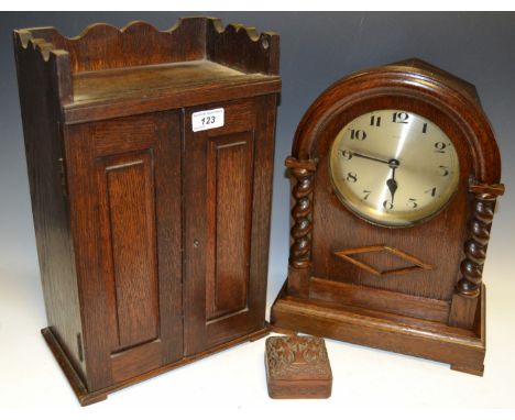 An early to mid 20th Century oak mantel clock, eight day movement, silvered dial, roman numerals circa. 1930; an oak smokers 