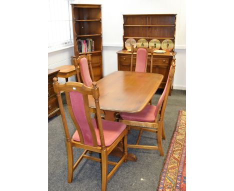 An Ercol  dining room suite comprising of four high back Hampton design dining chairs, shaped upholstered splats, turned supp