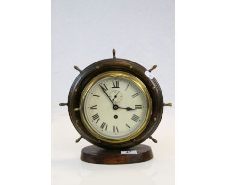 Vintage key wind Brass Ship's Bulkhead Clock in later wooden Ship's Wheel mount &amp; stand, approx 26.5cm tall in total