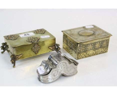Two brass cigarette boxes, one in Arts and Craft style and other with Griffin feet, plus a white metal snuff box with twin op