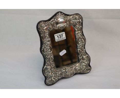 A hallmarked silver easel back mirror with cherub decoration. 