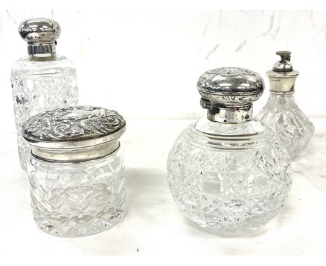 Two silver topped cut glass perfume bottles together with silver topped jar and silver topped perfume dispenser