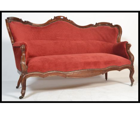 A Victorian mahogany double scroll end Chesterfield sofa settee. Raised on castors with scrolled legs supporting a tall, deep