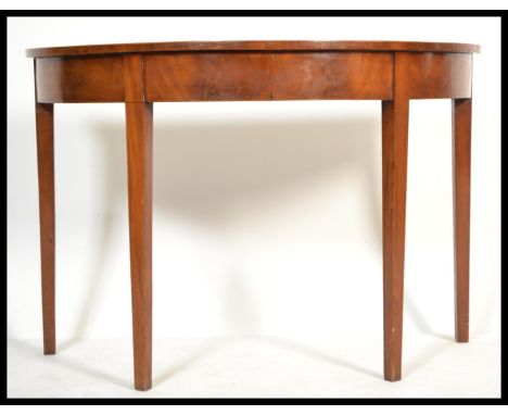 A Georgian 19th century mahogany demi lune console hall table being raised on square tapering legs with a fitted frieze havin