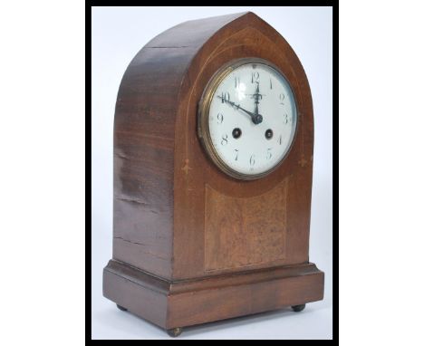 An Edwardian mahogany inlaid spire shaped mantel clock with 8 day brass clock movement, enamel dial with roman numeral chapte