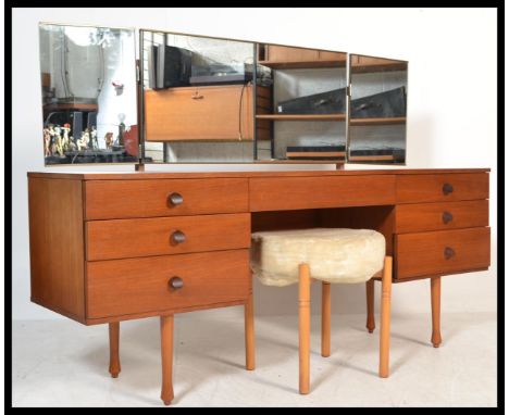 A vintage retro 20th century teak knee hole dressing table desk having a configuration of seven drawers with central recess a