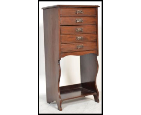 An Edwardian mahogany upright pedestal office filing cabinet having open shelf with fall front bank of drawers above. 