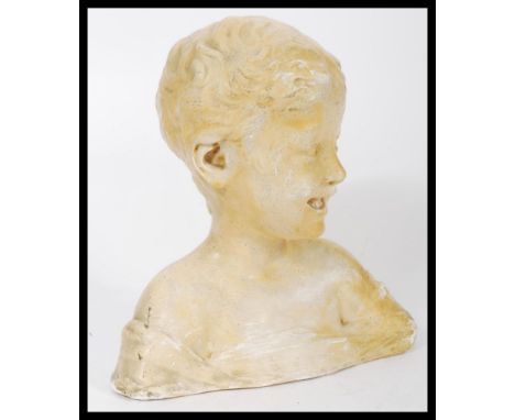 A vintage early 20th century plaster work bust of a smiling boy with impressed marks to verso Chenil, Chelsea. Measures 31cm 