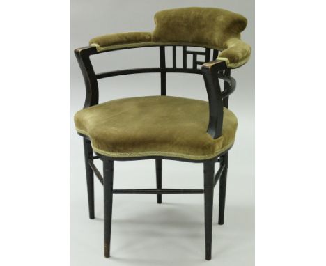 A Victorian Aesthetic ebonised framed armchair after a design by E W Godwin by Gillow & Co. circa 1875, the upholstered scrol