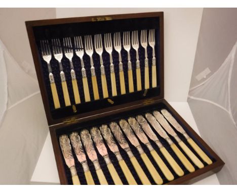 A cased set of twelve late Victorian silver-bladed and pronged fish knives and forks with engraved foliate decoration and ivo