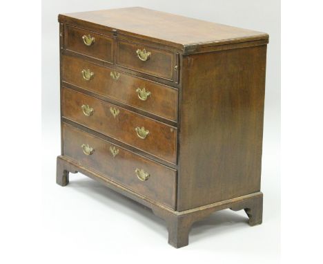 An early 18th Century quartered and cross and feather banded walnut bachelor's chest with fold-over top above the two short a