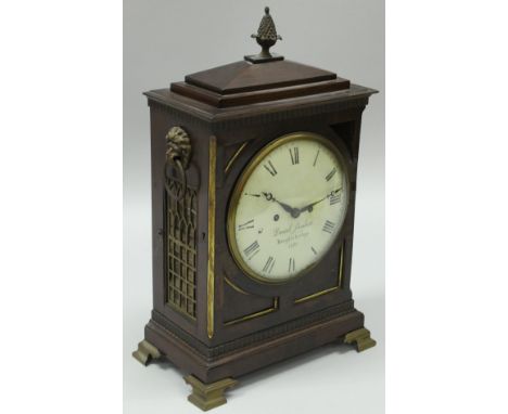 A 19th Century mahogany cased mantle clock, the caddy top with pineapple finial flanked by lion mask ring handles raised on b