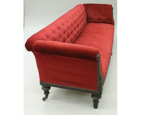 A Victorian mahogany framed show frame sofa, the buttoned upholstered back and arms over a plain upholstered seat, flanked by