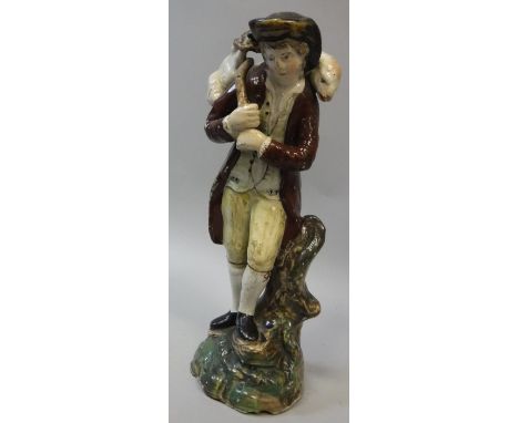 An early 19th Century Staffordshire pearl ware figure group of a shepherd with sheep upon his shoulders, hollow bottom, 20 cm
