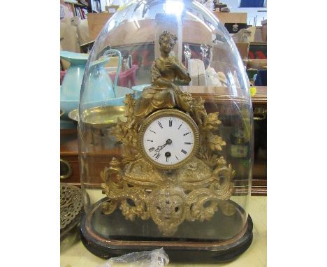 A gilt metal mantel clock, the drum movement surmounted by a woman, with scrolls and leaves, under a glass dome, height inclu